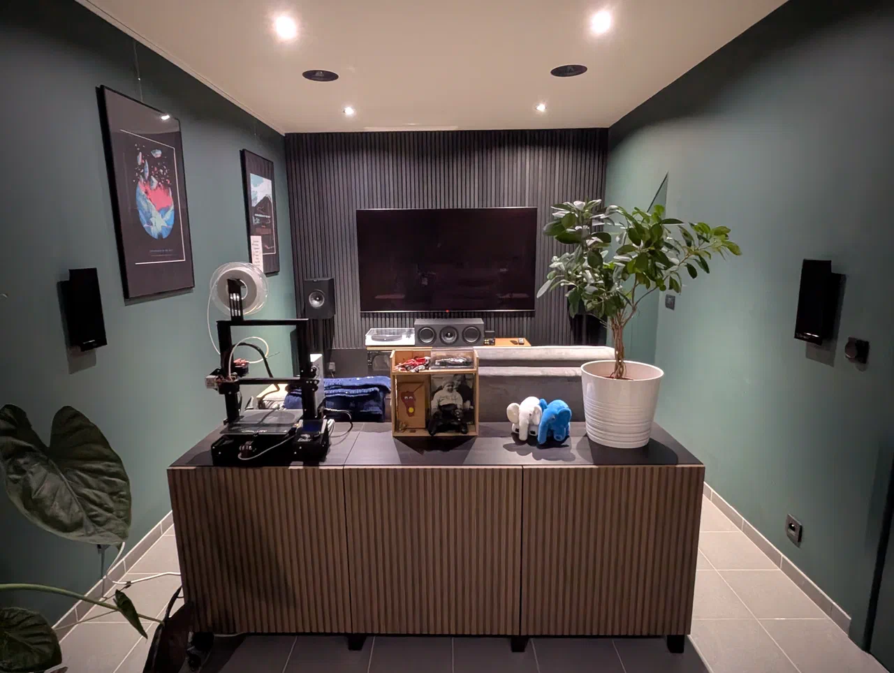 Couch in front of a TV with surround speakers, walls painted green
