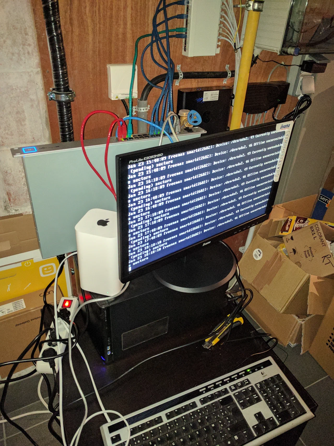 A monitor on a black rectangular computer case in a garage