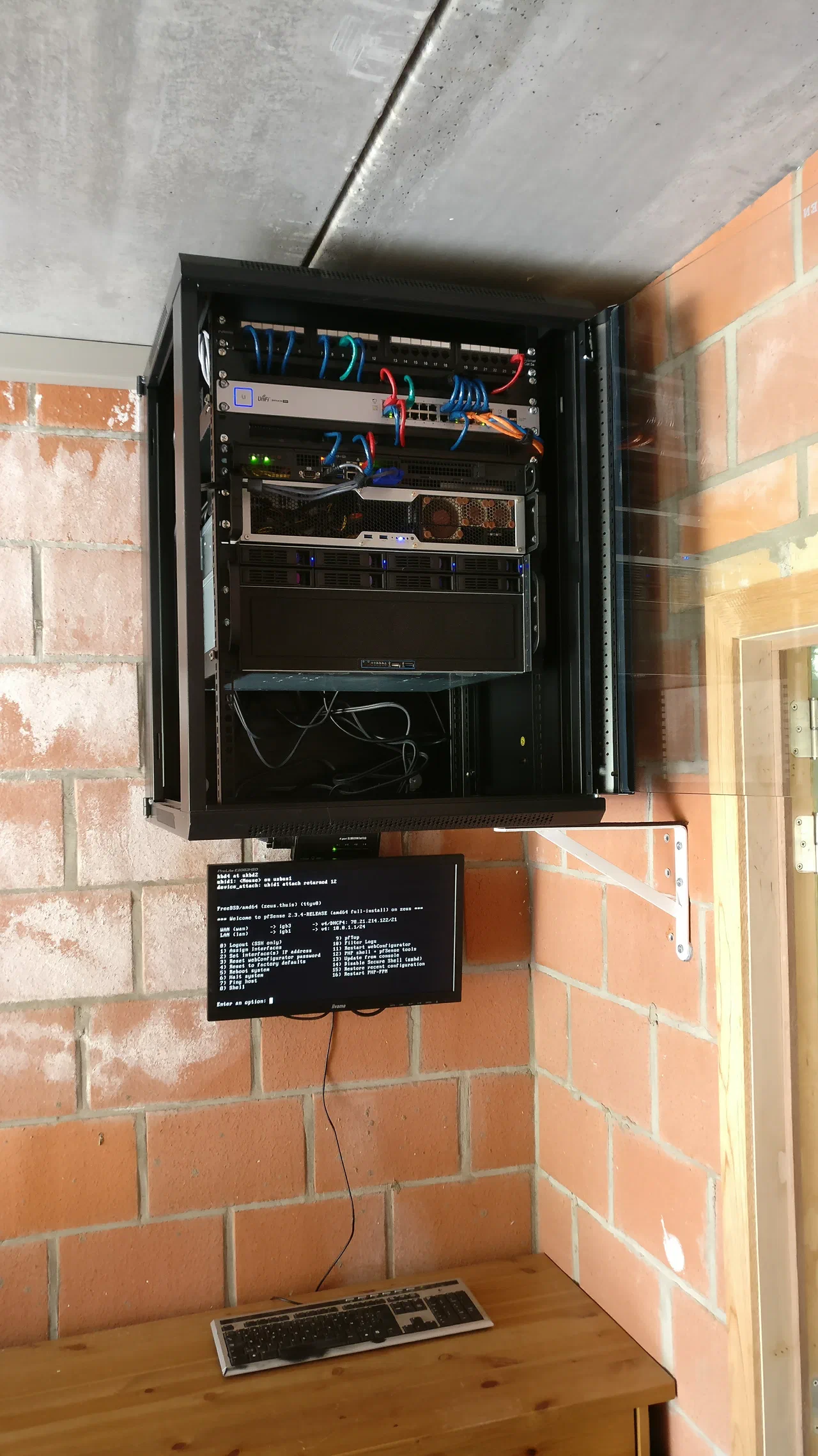 Server rack mounted at ceiling height with multiple servers and a monitor below it
